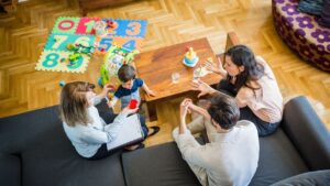 Young couple with a child with a therapist. They are in their living room.